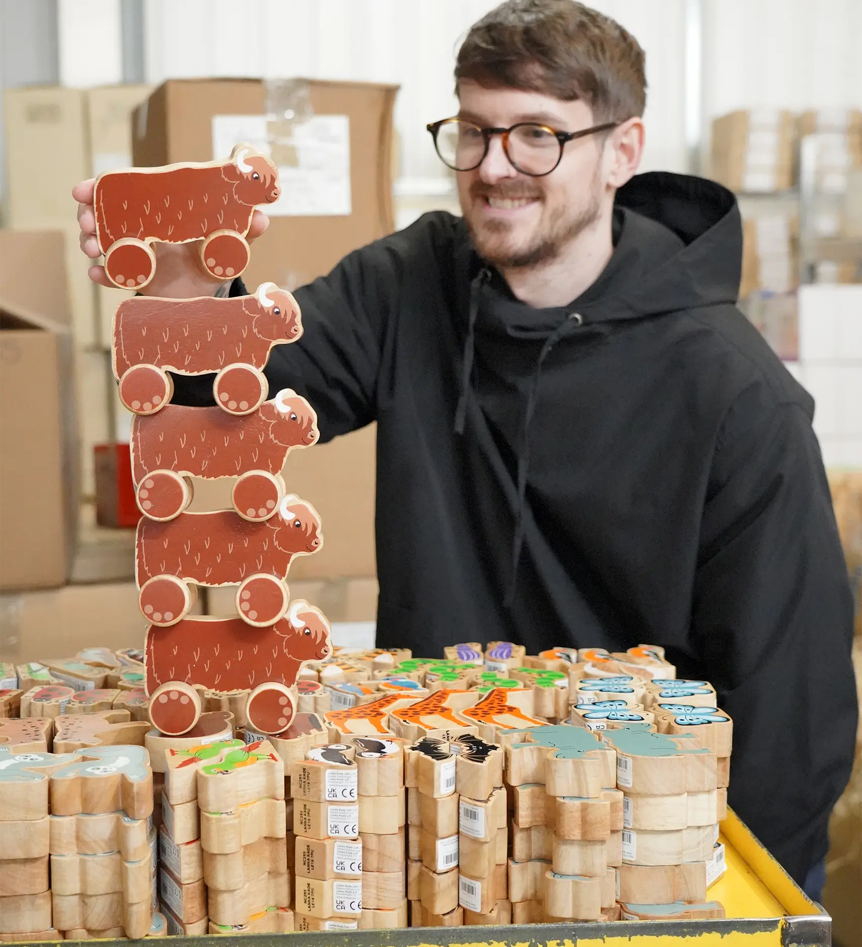 Lanka Kade Highland Cow Push Along Wooden Toys stacked in the Babipur warehouse.