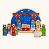 Lanka Kade wooden Nativity scene toy set featuring colorful painted wooden figures of animals and biblical characters, arranged in front of a wooden stable.