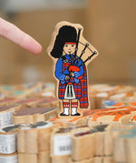 Lanka Kade Wooden Scottish Bagpiper toy in a kilt in the Babipur Warehouse.