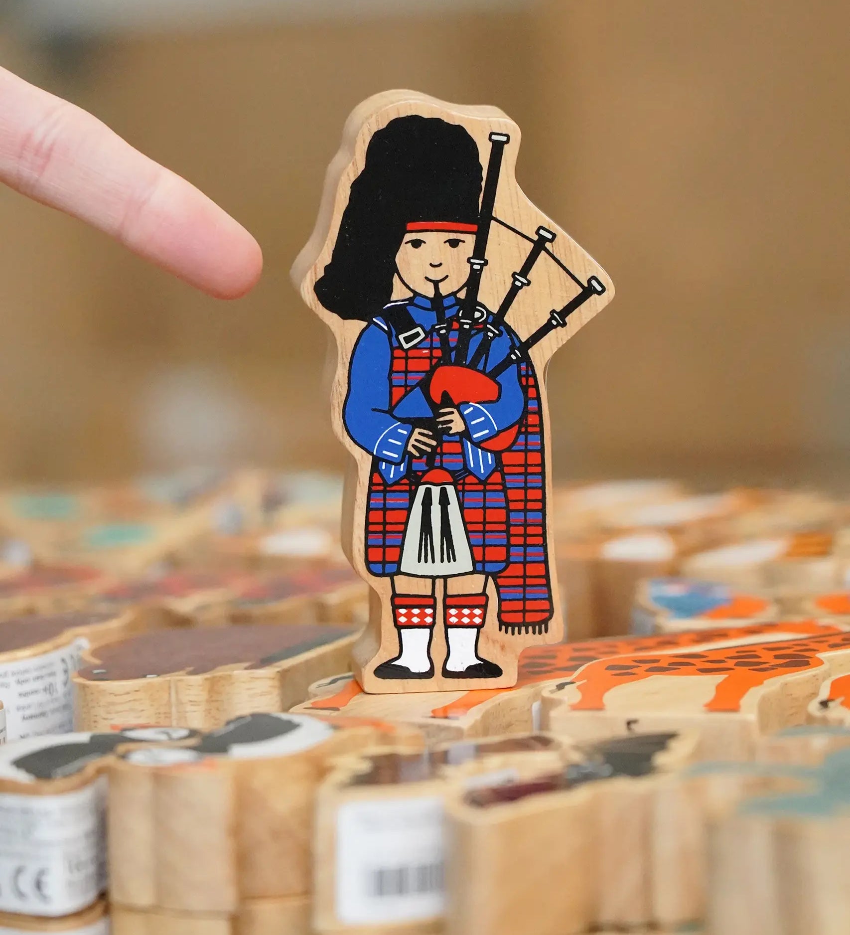 Lanka Kade Wooden Scottish Bagpiper toy in a kilt in the Babipur Warehouse.