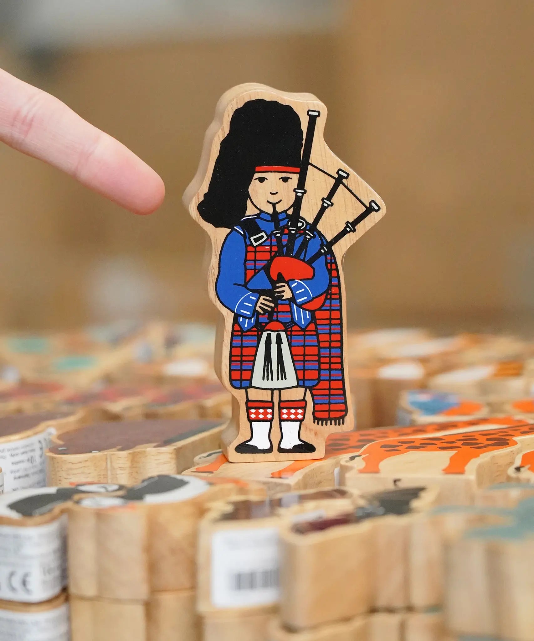 Lanka Kade Wooden Scottish Bagpiper toy in a kilt in the Babipur Warehouse.