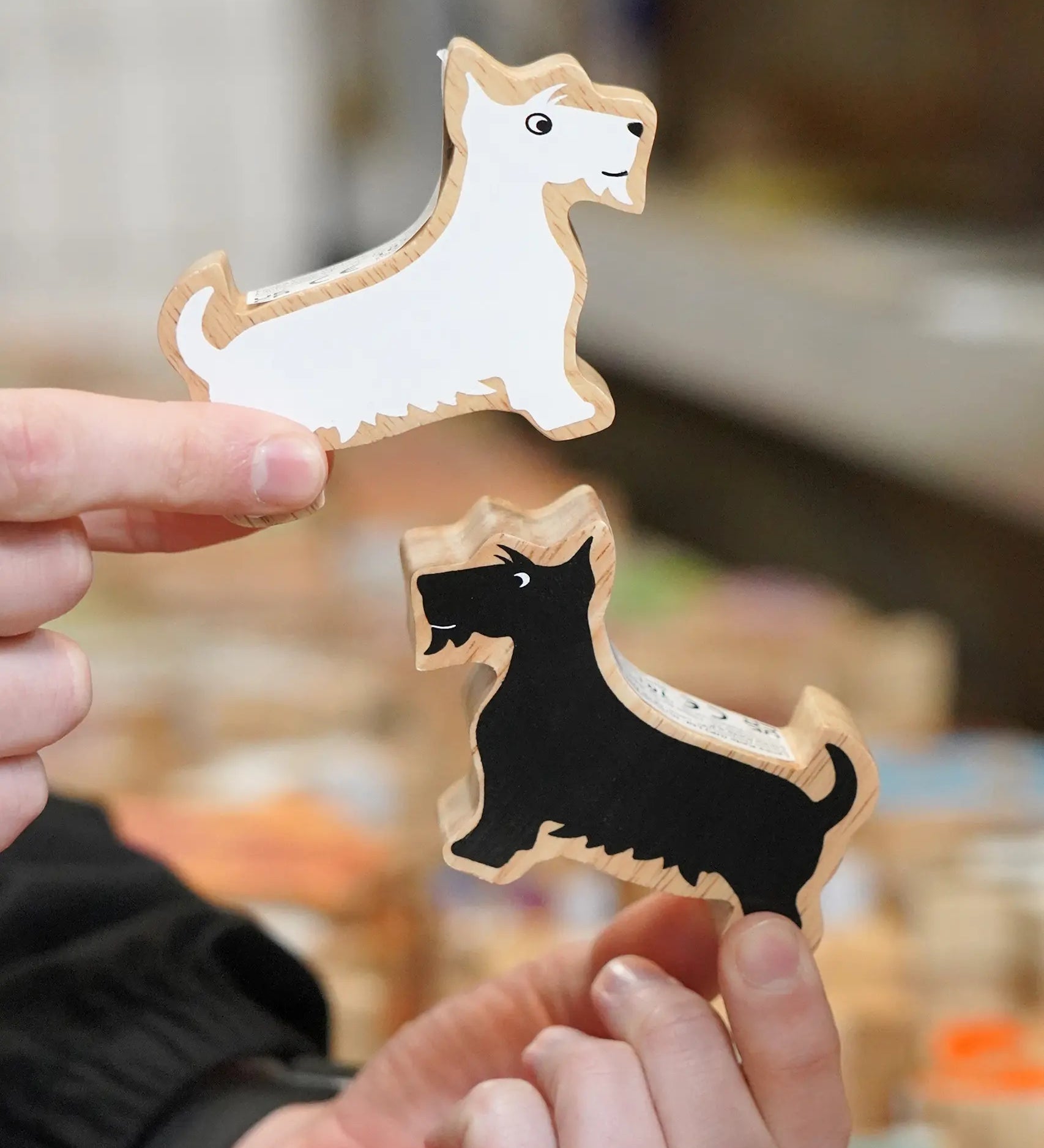 Lanka Kade Scottie Dogs wooden toys in black and white, part of the Scottish collection, in hands in the Babipur warehouse.