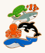 Lanka Kade Wooden Sealife Animals Bag of 6, are fun marine life figures and include a whale, an octopus, an orca, a shark, a turtle and a clown fish, all with happy and smiling faces. The image is on a cream background