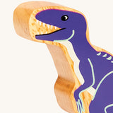 A close up of the A chunky wooden Lanka Kade velociraptor dinosaur figure available at Babipur showing its purple painted body.