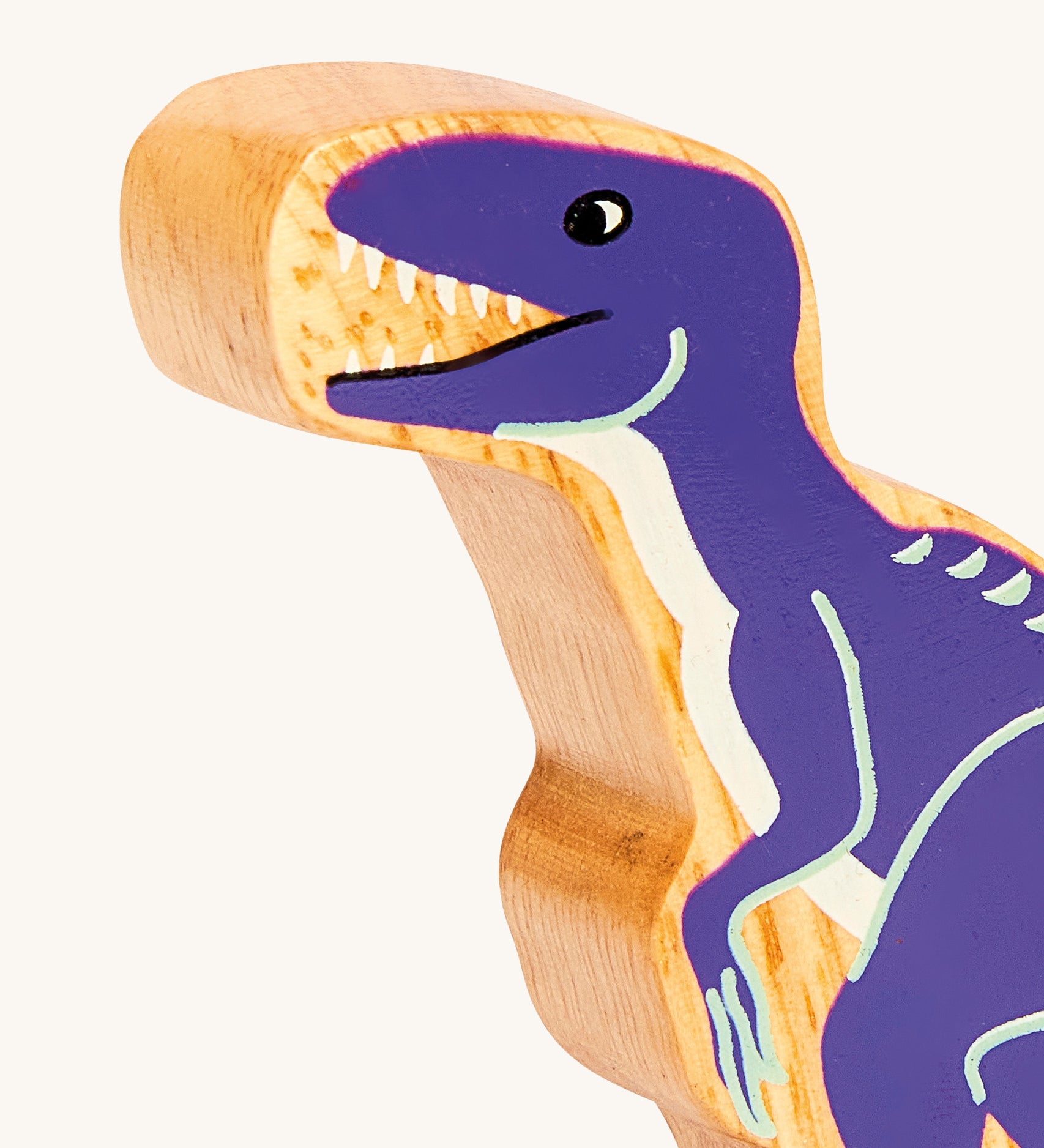 A close up of the A chunky wooden Lanka Kade velociraptor dinosaur figure available at Babipur showing its purple painted body.