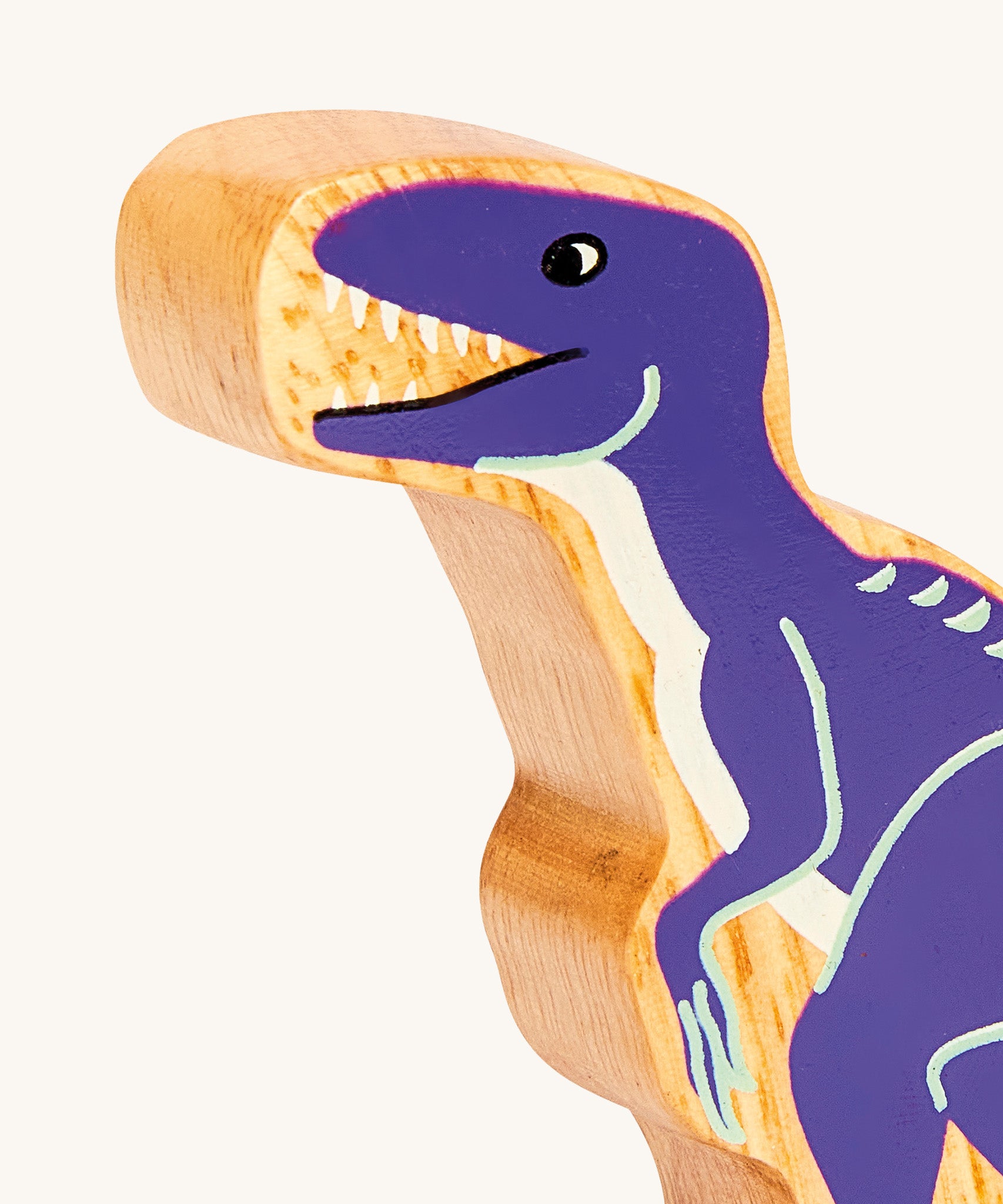 A close up of the A chunky wooden Lanka Kade velociraptor dinosaur figure available at Babipur showing its purple painted body.