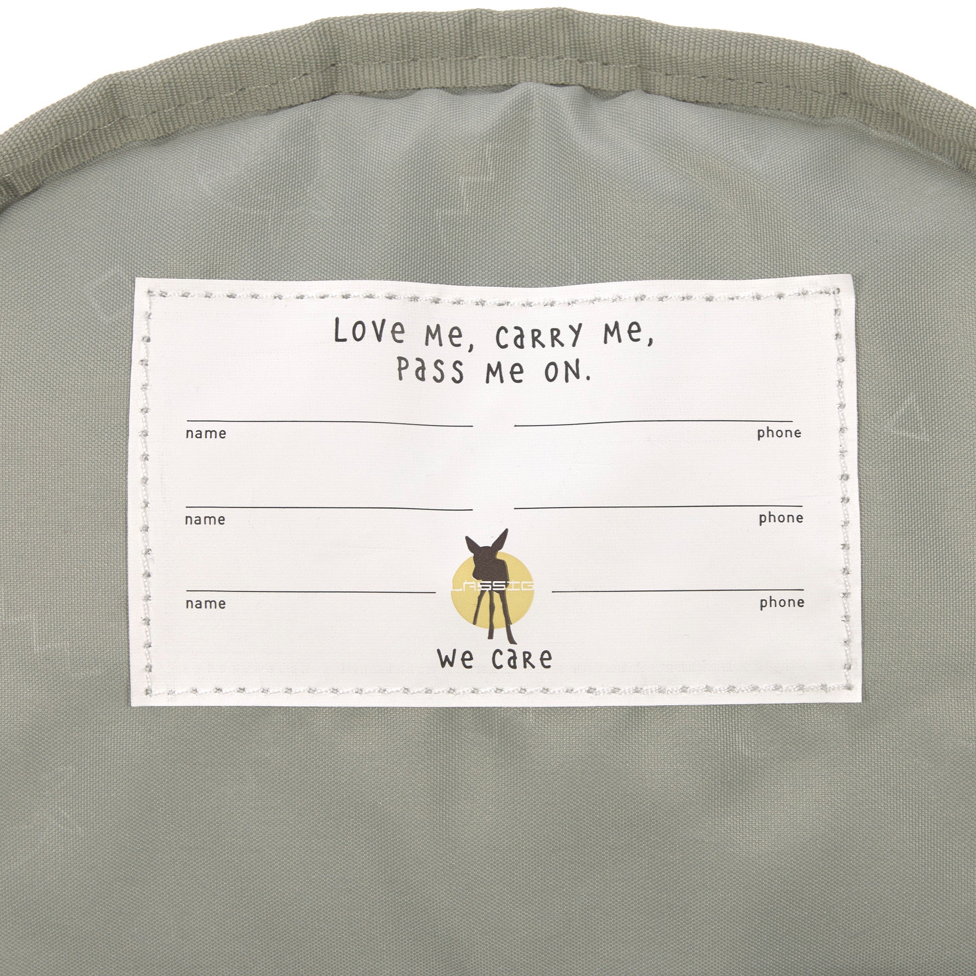 A close up of the Lassig kids mini caramel happy print backpack showing the white name tag on the inside