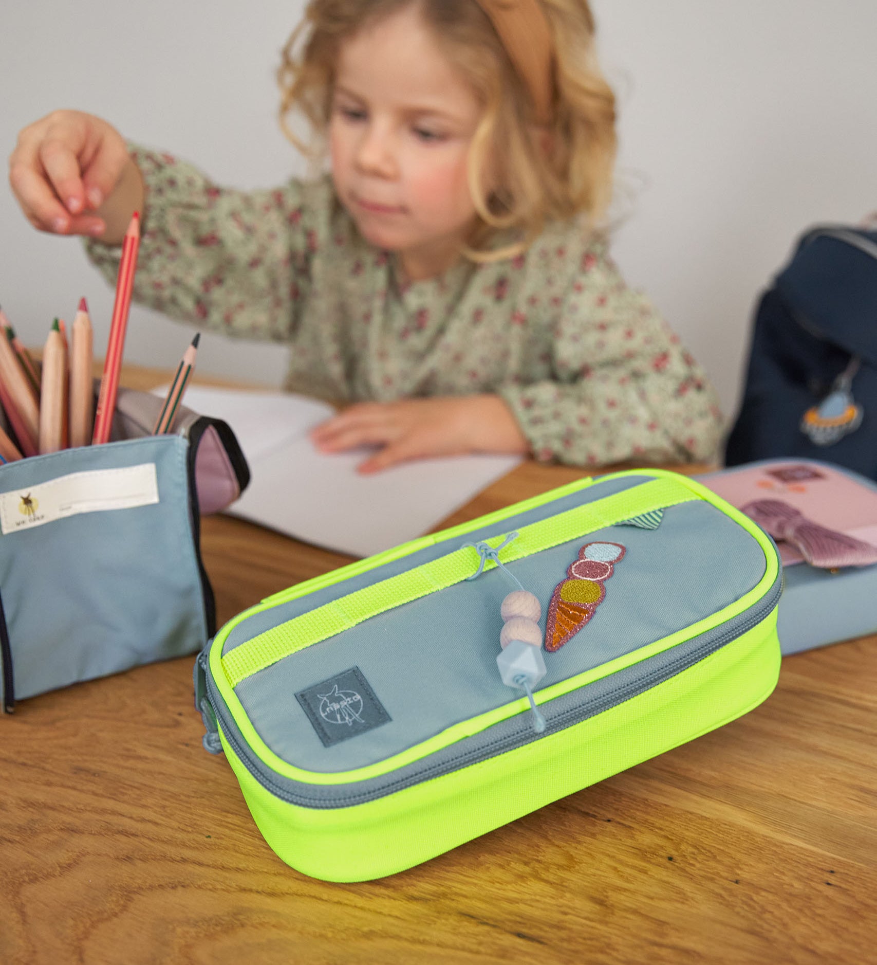 Lassig spacy school pencil case in neon yellow with a funky decorative patche and hanging wooden tag.