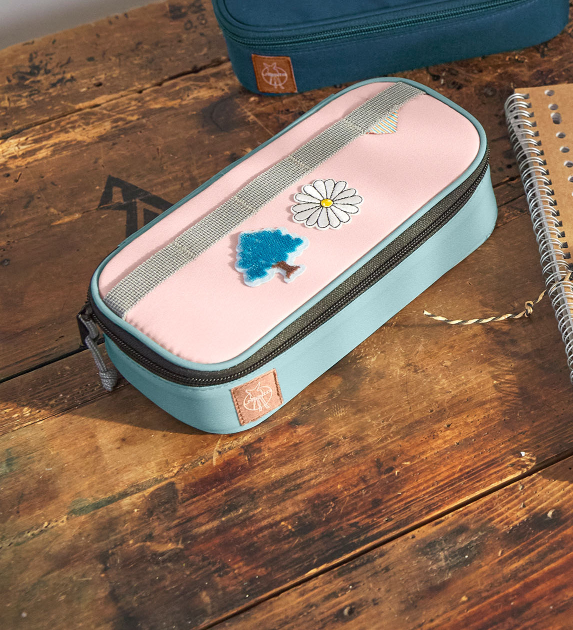 Lassig spacy school pencil case in navy and pink with cute decorative patches on a wooden desk