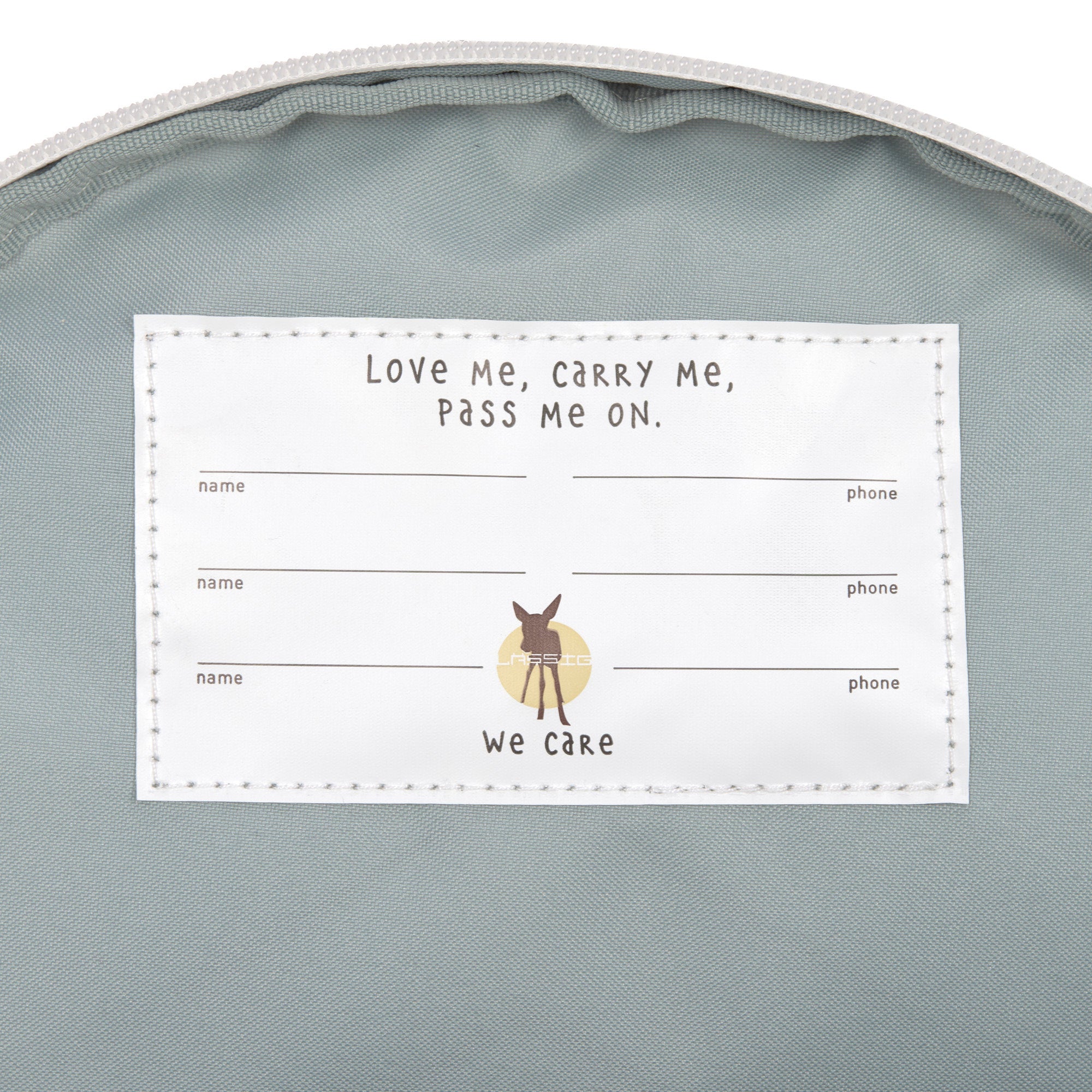 The inside of the Lassig kids tiny Dino backpack, showing the name label that has multiple spaces for when the bag is passed on to younger kids. 