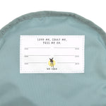 The inside label of the Lassig tiny backpack for toddlers and little kids, in a light pink.