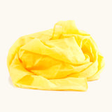 Bright yellow 100% organic cotton play cloth ruffled up into a pile