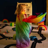 Child playing with Laura's play cotton bright rainbow play cloths in a playroom 