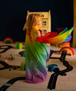 Child playing with Laura's play cotton bright rainbow play cloths in a playroom 