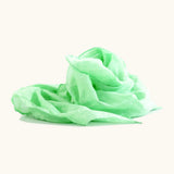 Light green 100% organic cotton play cloth ruffled up into a pile