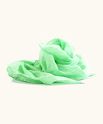Light green 100% organic cotton play cloth ruffled up into a pile