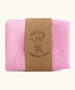 Laura's 100% organic cotton play cloth in pink held together by a decorated cardboard strip