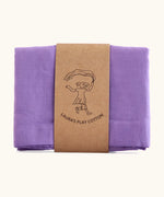 Laura's 100% organic cotton play cloth in violet held together by a decorated cardboard strip