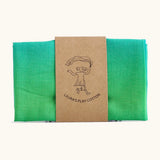 Laura's 100% organic cotton small play cloth in a green gradient held together by a decorated cardboard strip