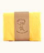 Laura's 100% organic cotton play cloth in yellow held together by a decorated cardboard strip