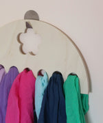 A collection of Laura's 100%organic cotton play cloths on a wooden hanger 