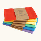 Stack of Laura's play cotton cloths in rainbow inspired colours. Made from 100% organic cotton