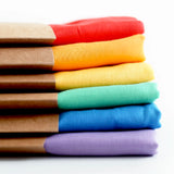 Stack of Laura's play cotton cloths in rainbow colours. Made from 100% organic cotton 