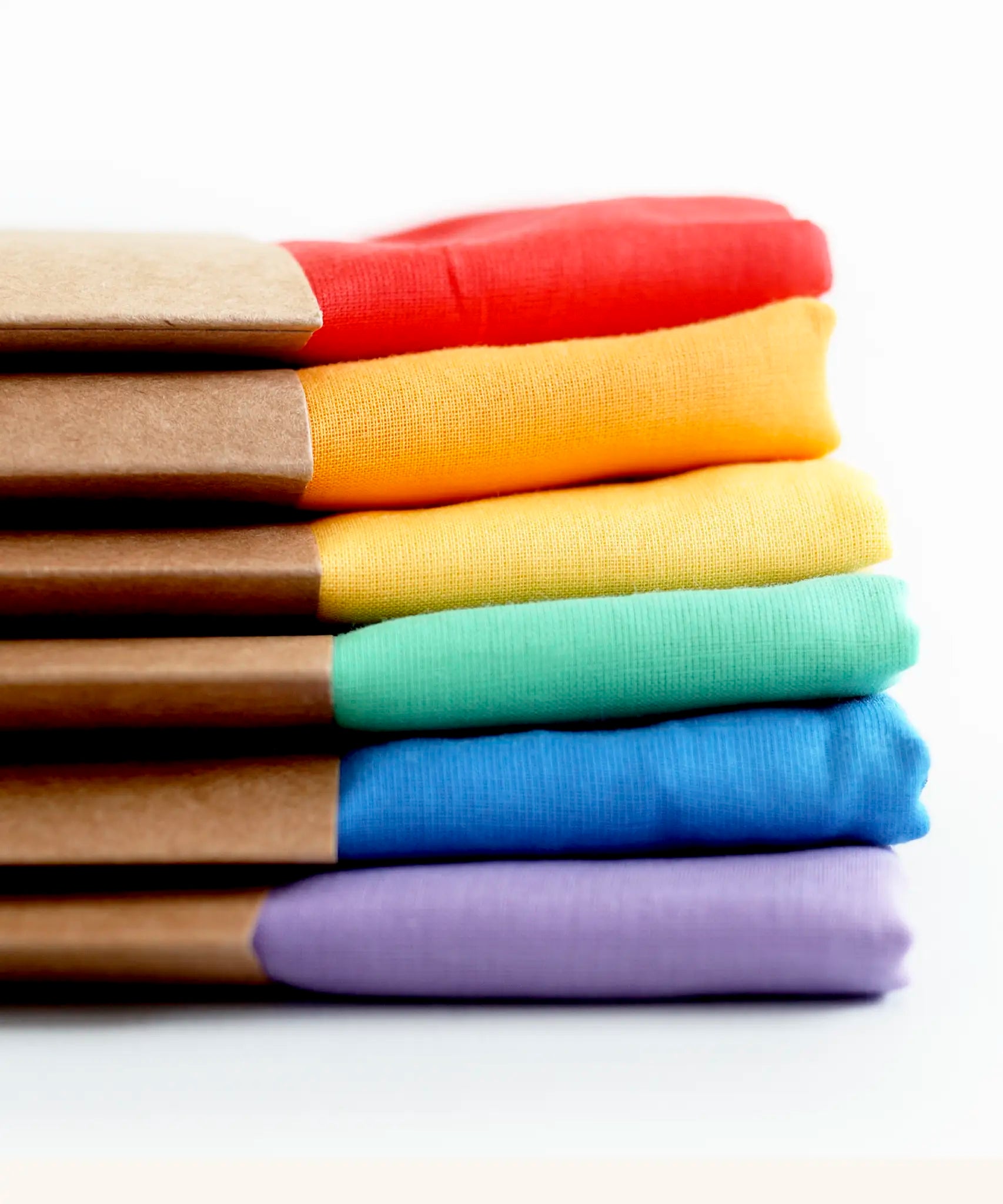 Stack of Laura's play cotton cloths in rainbow colours. Made from 100% organic cotton 