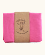 Laura's 100% organic cotton play cloth in hot pink held together by a decorated cardboard strip