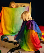 Children playing with Laura's play cotton rainbow cloths made from organic cotton in a playroom