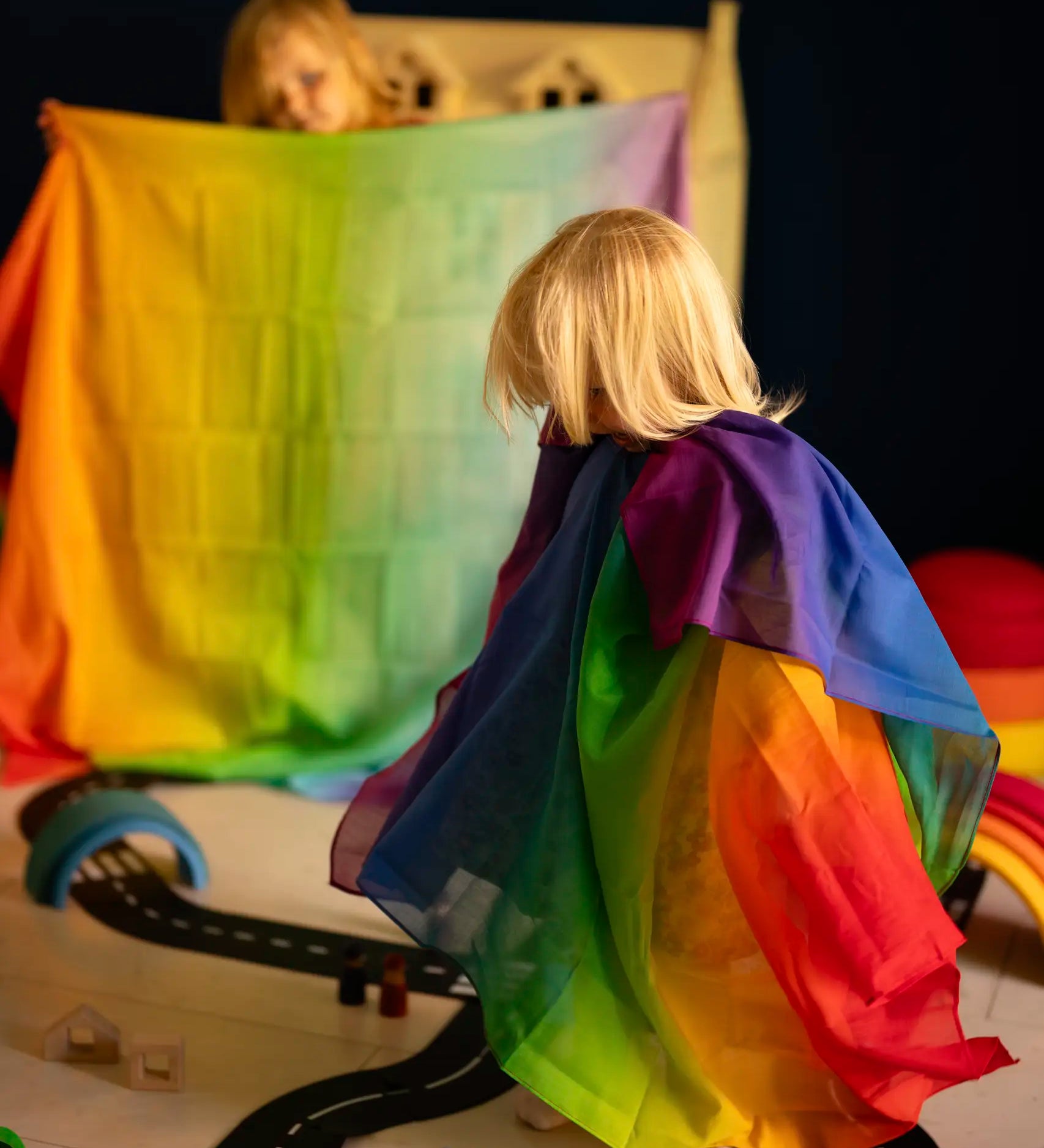 Children playing with Laura's play cotton rainbow cloths made from organic cotton in a playroom