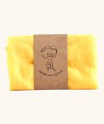 Laura's 100% organic cotton small play cloth in yellow held together by a decorated cardboard strip