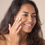 A person rubbing in the Green People Nordic Roots Hyaluronic Booster Serum, in to their skin. The serum is sheer and non greasy in texture