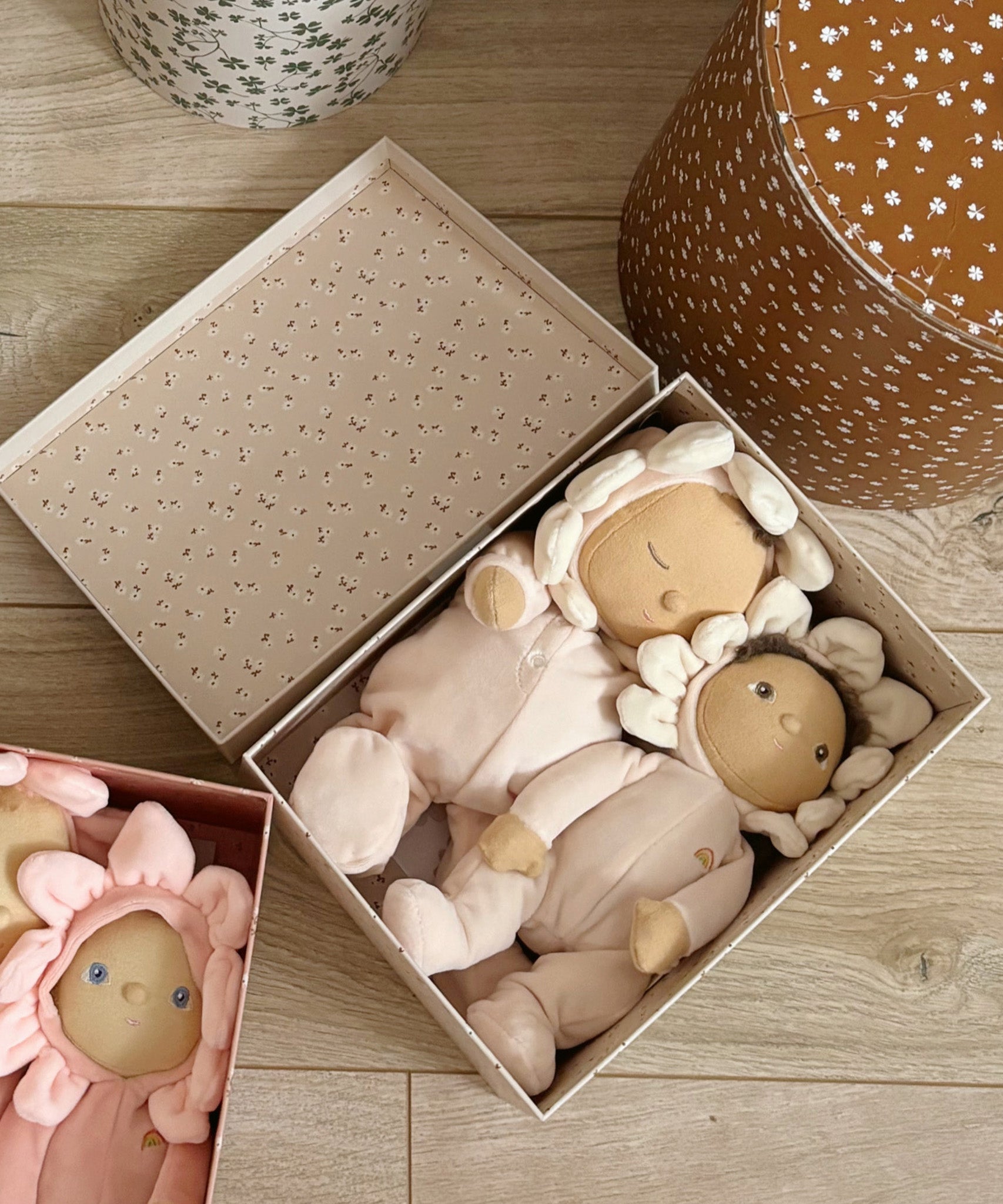 The Olli Ella Limited Edition Blossom Buds Gift Set - Gardenia, showing the Tootsie Gardenia & Dinky Dinkum Doll - Gracie Gardenia inside their gift box, on a wooden floor