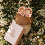 Olli Ella Limited Edition Blossom Buds Gift Set - Tulip showing Dozy Dinkum - Talia Tulip & Dinky Dinkum Doll - Tessa Tulip sat inside an Olli Ella basket on a flowery setting, with the packaging box lent against the basket