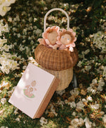 Olli Ella Limited Edition Blossom Buds Gift Set - Tulip showing Dozy Dinkum - Talia Tulip & Dinky Dinkum Doll - Tessa Tulip sat inside an Olli Ella basket on a flowery setting, with the packaging box lent against the basket