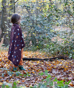 A brown flying birds patterned knitted baby blanket by Little Green Radicals — made with Fairtrade and GOTS-certified organic cotton — keeps a child warm in the forest, offered at Babipur.