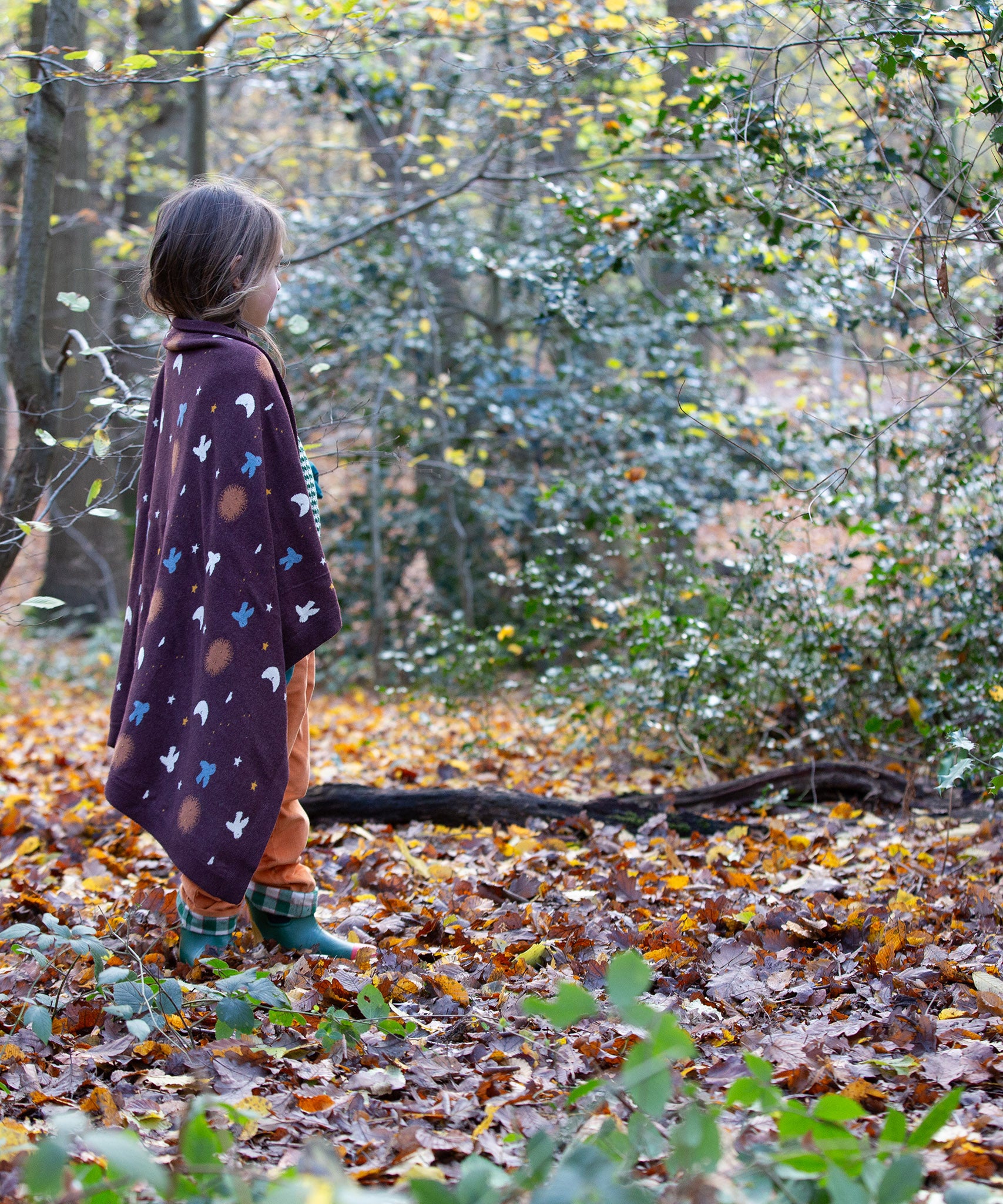 A brown flying birds patterned knitted baby blanket by Little Green Radicals — made with Fairtrade and GOTS-certified organic cotton — keeps a child warm in the forest, offered at Babipur.