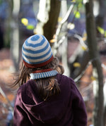 Back of child's head wearing a Little Green Radicals Fairtrade Knit Beanie in blue and cream stripes - made with GOTS organic cotton - shop now at Babipur.