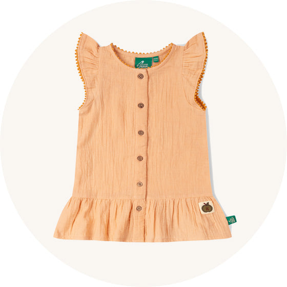Little Green Radicals Muslin Dress in Coral Pink with wooden buttons, a frill bottom and fluted sleeves, made from organic muslin cotton, to represent all Little Green Radicals dresses at Babipur. 