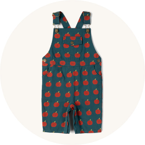 Little Green Radicals Dungaree Shorts in green and red all over apple print, made from organic cotton, to represent all Little Green Radicals dungarees at Babipur. 