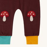 A close up of the Little Green Radicals knee patch joggers in toadstool design showing the toadstool knee patch detail
