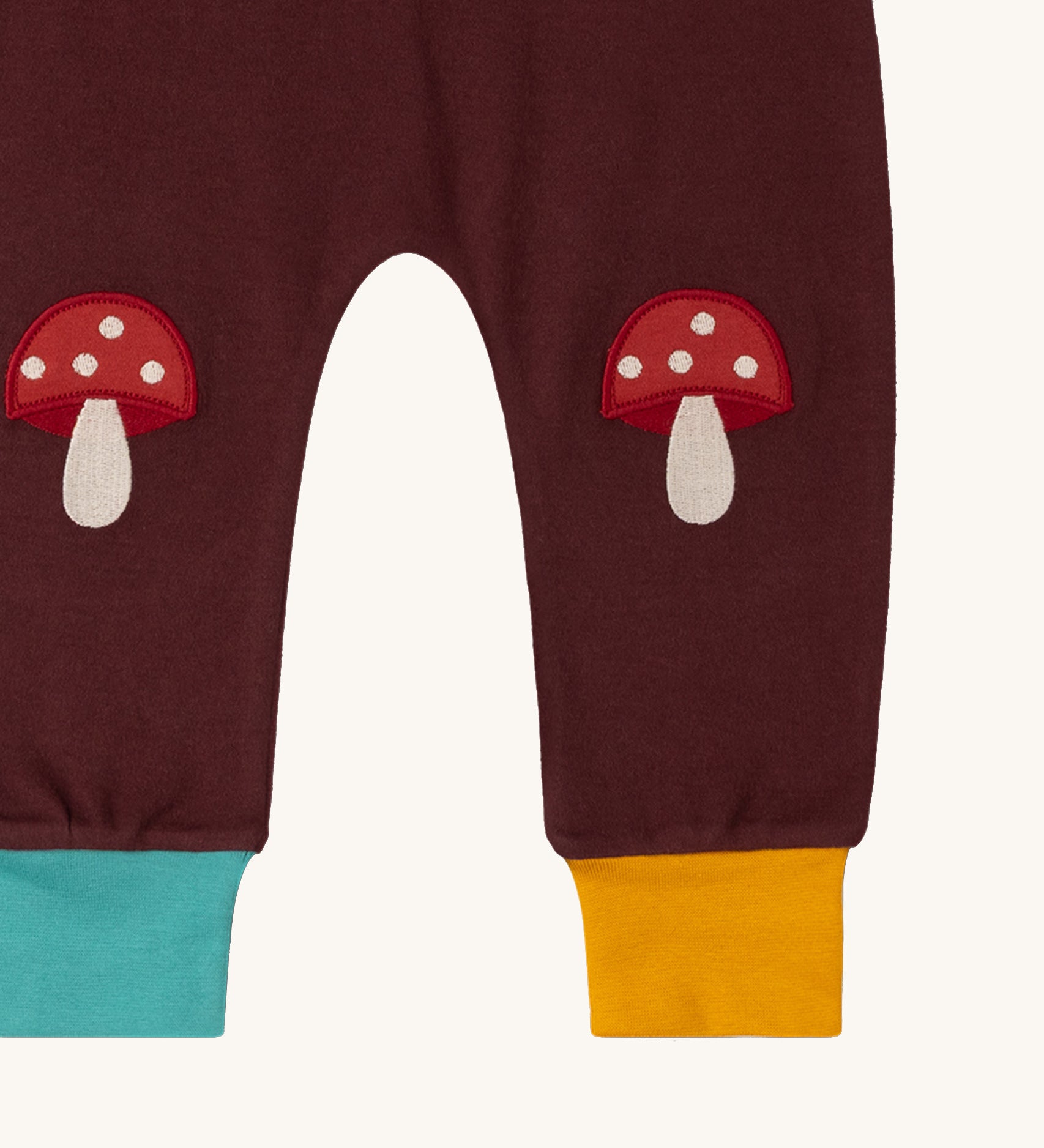 A close up of the Little Green Radicals knee patch joggers in toadstool design showing the toadstool knee patch detail