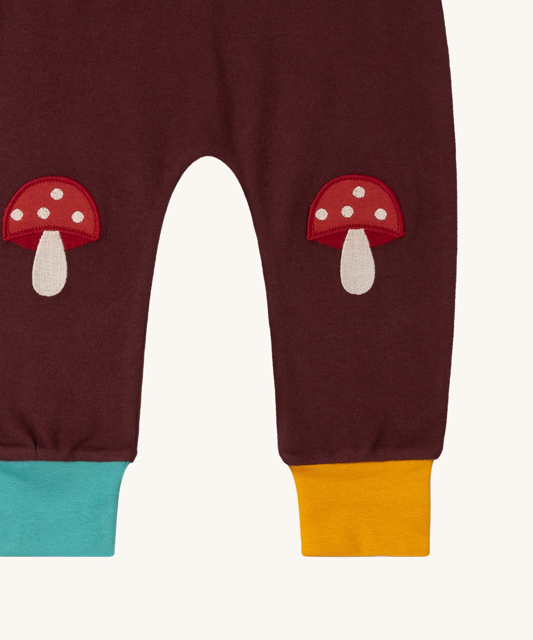 A close up of the Little Green Radicals knee patch joggers in toadstool design showing the toadstool knee patch detail