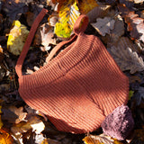 Little Green Radicals Knitted Ginger Orange Kids Hat with a brown pom pom and chin straps, made from soft and warm Fairtrade and organic cotton - for sale at Babipur.