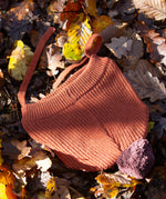 Little Green Radicals Knitted Ginger Orange Kids Hat with a brown pom pom and chin straps, made from soft and warm Fairtrade and organic cotton - for sale at Babipur.