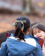 Close up of the back of a child outdoor wearing a Kids Warm Waterproof, 5000MM rating, PFC Free, Winter Hooded School Coat in Moonlight Blue print, with a cosy and fluffy lined hood, by Little Green Radicals, made from recycled bottles and a cosy polyester fleece, buy now at Babipur.
