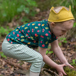 A child playing in a forest, wearing the LGR Vegetable Patch Short Sleeve T-Shirt