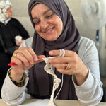 A Syrian Refugee crocheting the start of a teddy