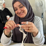 A Syrian Refugee crocheting the start of a teddy
